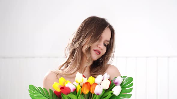 Beautiful Young Woman with a Bouquet of Colorful Tulips