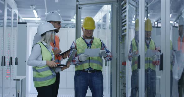 Three Electrical Workers Reviewing Documents