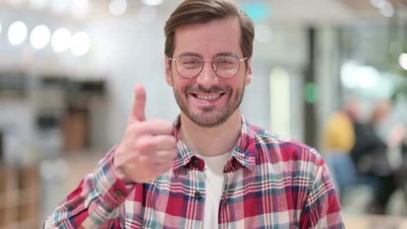 Portrait of Positive Male Designer Doing Thumbs Up 