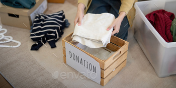 Donation, asian young woman sitting pack object at home, putting on stuff into donate box with