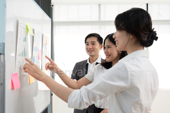 A team of Asian businessmen meets to brainstorm ideas about office work management in an office