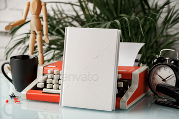 Hardcover book and vintage typewriter on white desk