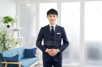 A businessman wearing a custom suit and saying hello