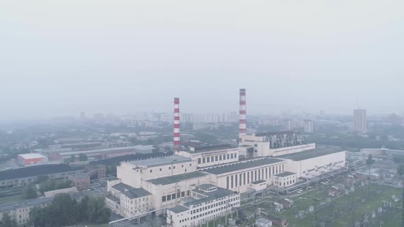 Industrial Buildings with Pipes and the City Shrouded in Smoke. Air Pollution and Environmental