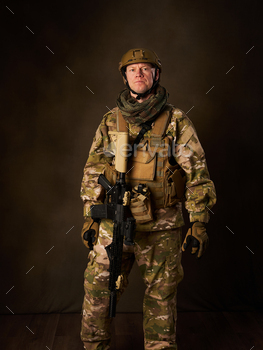 a young military soldier with automatic airsoft rifle with telescopic vision