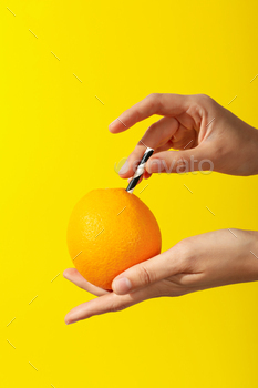 Fresh juicy orange with a tube inside