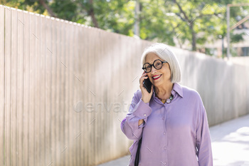 senior woman walking and talking on the phone