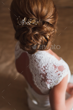 Wedding hairstyle. Bride. The brown-haired girl with curly hair, styling with barrette.