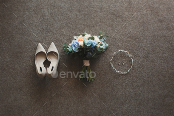 Tender beige wedding shoes and earrings and a wedding bouquet