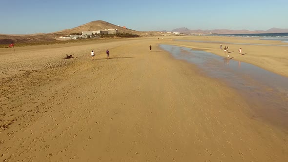 Aerial view of woman walking at Sotavento lagoon beach.