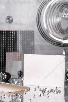 Envelope mockup and silver decorations on silver background , copy space