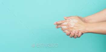 Hands washing gesture with foaming hand soap on green and Tiffany Blue  background.