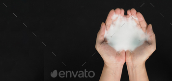 Hands washing gesture with foaming hand soap top view on black background.