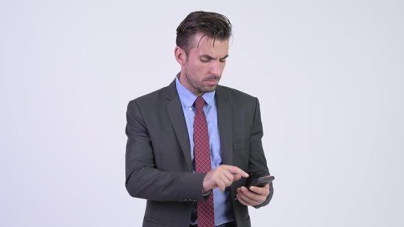 Young Stressed Hispanic Businessman Using Phone and Getting Bad News