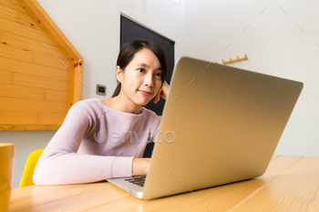 Asian Woman surf the internet by laptop computer