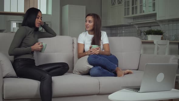 Multi ethnic girls girls talking on sofa