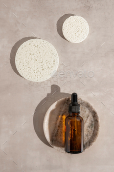 A bottle with face serum, essential oil or essential oil on a marble plate, natural care.