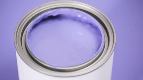 Close up of metal paint can with purple paint and paint swatch.