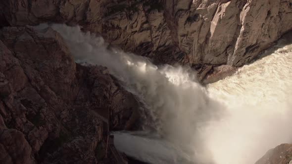 Panning view of water flowing out of Buffalo Bill Dam