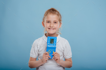 little girl with blue tetris game in child hand, isolated on white background,