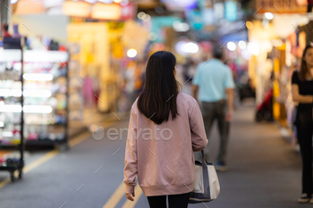 Woman walk into the street night market in Taipei