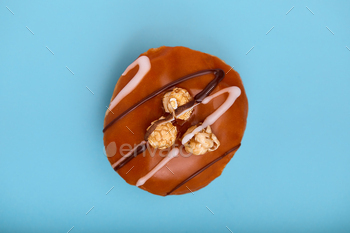 sweet donut on a blue background with chocolate icing. top view blue background, color game, sweet