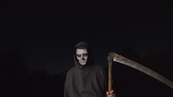 Scary Death Reaper with Scythe Creeping at Dusk