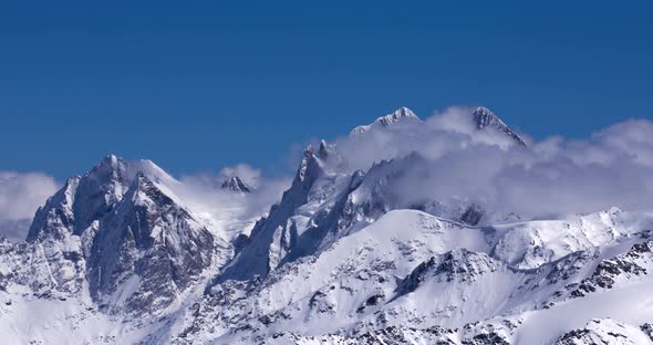 Timelapse of clouds flowing over a mountain range.