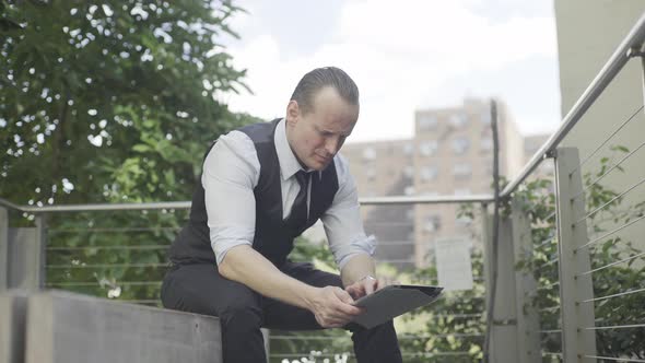 Businessman using digital tablet outdoors