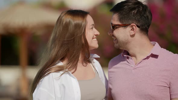 Portrait of a Woman with Long Hair in a White Shirt and a Man in Dark Glasses and a Pink Tshirt on a