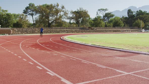 Disabled mixed race man with prosthetic legs running on race track