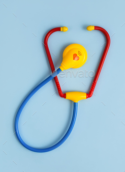 Toy stethoscope on a blue background. Children's medicine. Pediatrics. Doctor game.
