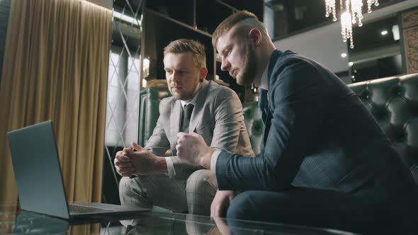 Business Executives Is Looking at Laptop Screen While Having a Discussion in the Office