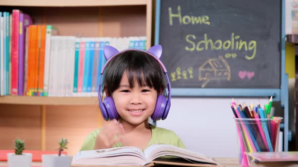 Cute little girl with headphones and tablet listening to music at home. happy childhood. h