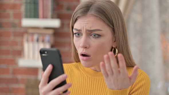 Portrait of Young Woman Reacting to Loss on Smartphone