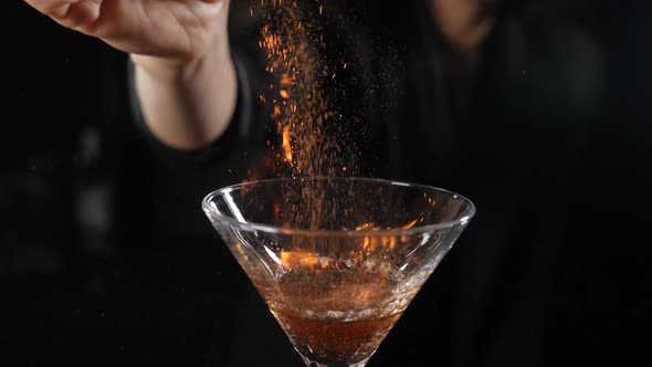 Bartender Sets Fire To Cocktail, Burning Cinnamon in Alcohol Drink on Black Background. Flames in