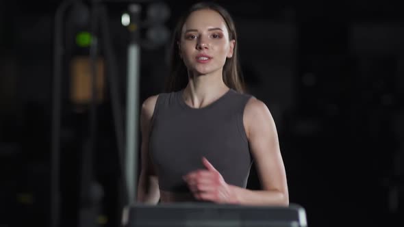 Portrait Young Female Athlete Run on a Treadmill Aerobic Exercise and Endurance Training a Runner