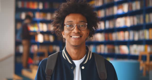 Portrait of Afroamerican Male Student Smiling at Camera in Campus Library