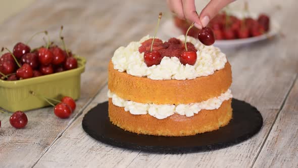 Young Female Confectioner Decorating Naked Cherry Cake.