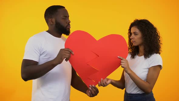 Multiracial Couple Holding Two Parts of Paper Heart, Breakup Relationship Crisis
