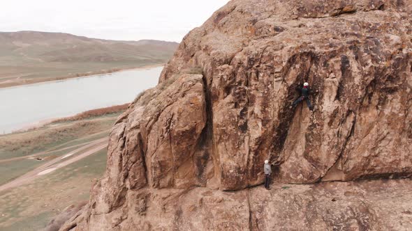 Man Athlette Climbing on the High Rock