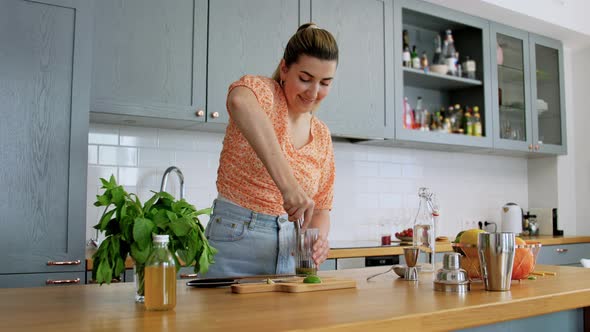 Woman Making Mojito Cocktail Drink at Home Kitchen
