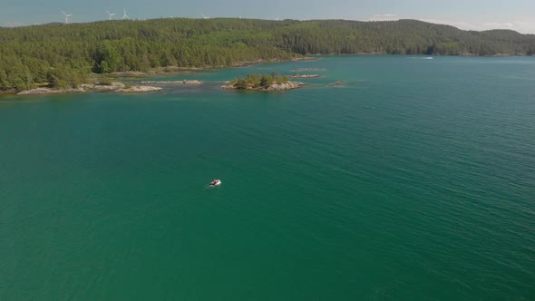 Drone following a small boat in sea.