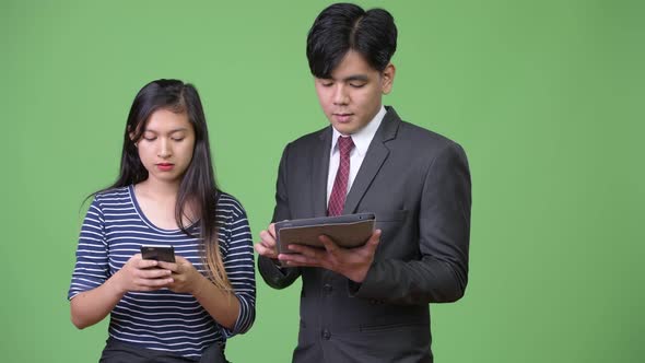 Young Handsome Asian Businessman and Young Asian Woman Working Together