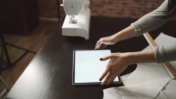 unrecognizable tailor using ruler near sewing machine in workshop