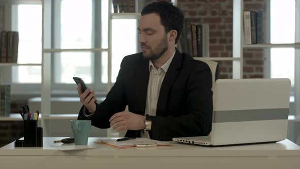 Man Sleeping on a Desk, Wake Up and Start Talking Phone