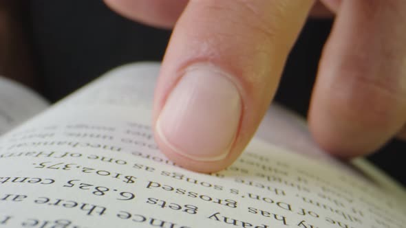 Macro Closeup of Person Reading Music Publishing Book with Finger