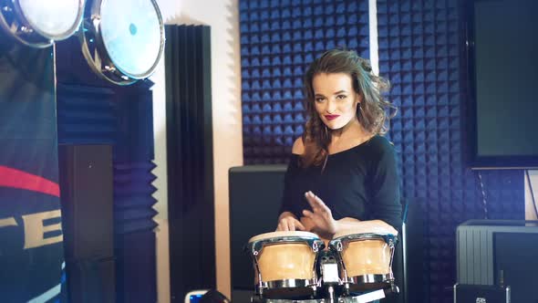 Beautiful woman dances playing drums. Professional recording studio.