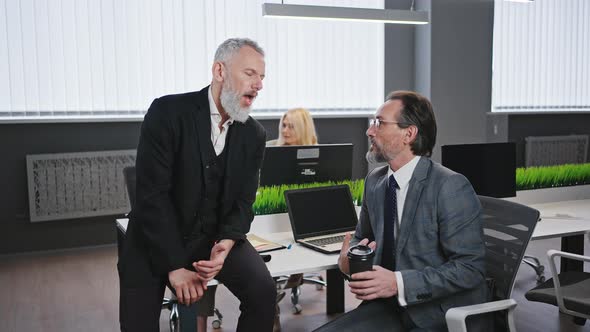 Two Elderly Men Coworkers Talking Together During Coffee Break at Office Zoom in Shot