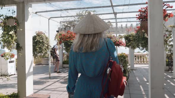 A girl walks with a Vietnamese hat in the park of Ba Na Hills, Vietnam